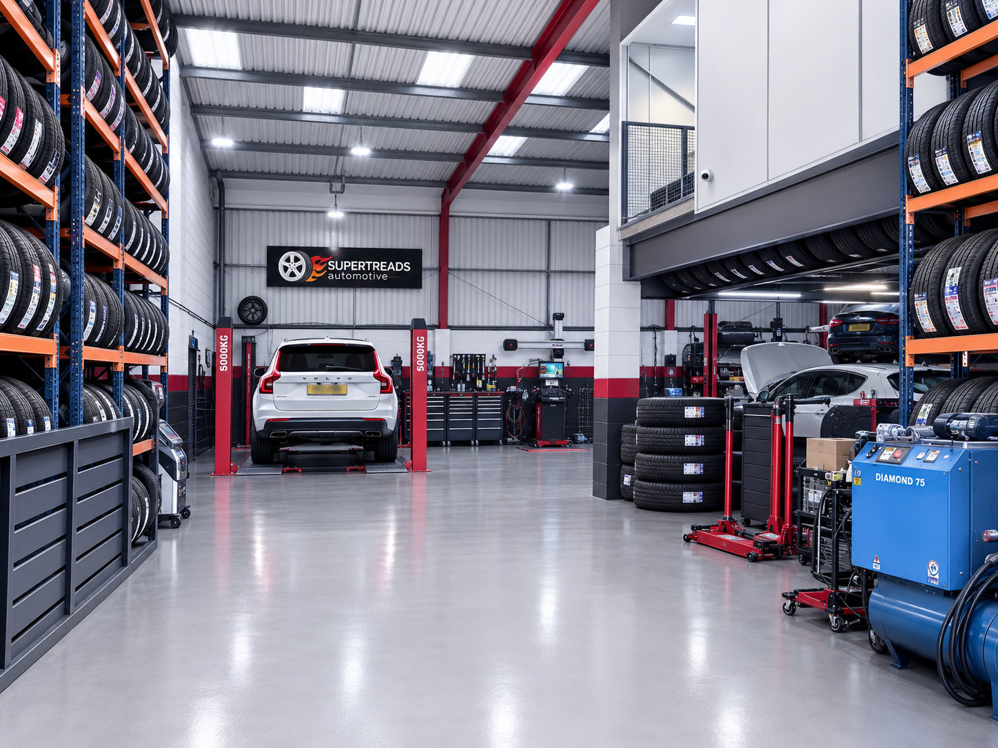 Wide view inside the Supertreads workshop, with tyre storage and vehicles in service bays.
